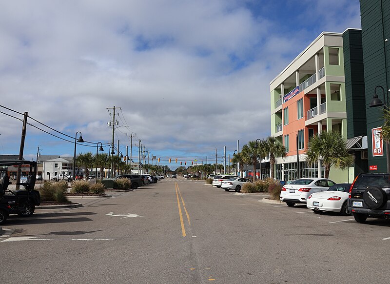 Carolina Beach boardwalk street view with shops and palm trees