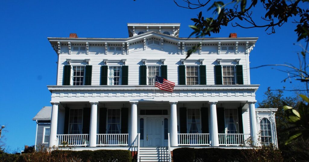 A historic white columned home with a covered porch in downtown Wilmington, North Carolina
