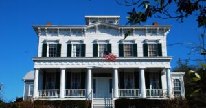 A historic white columned home with a covered porch in downtown Wilmington, North Carolina