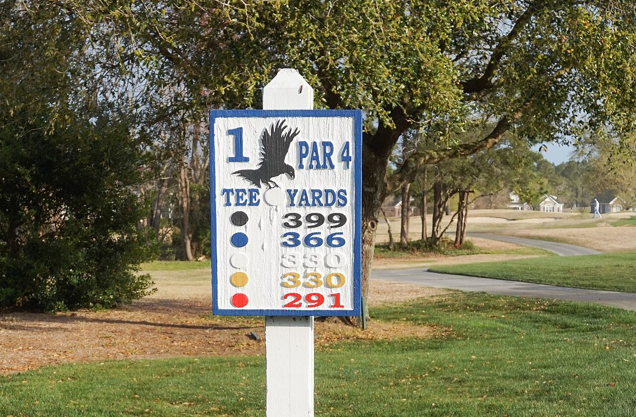 First tee sign at Crow Creek Golf Club in the Calabash area of Brunswick County, North Carolina, with the fairway, cart path and course-side homes behind it