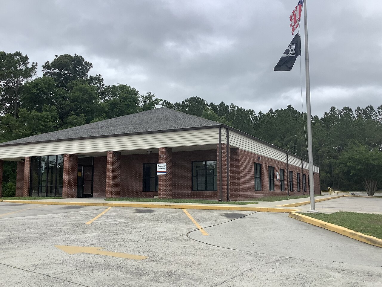 The brick United States Post Office building and customer parking lot in Shallotte, North Carolina