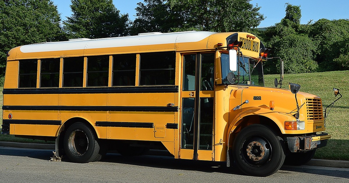 School bus on a residential street, representing school enrollment timing for families relocating to Wilmington, NC
