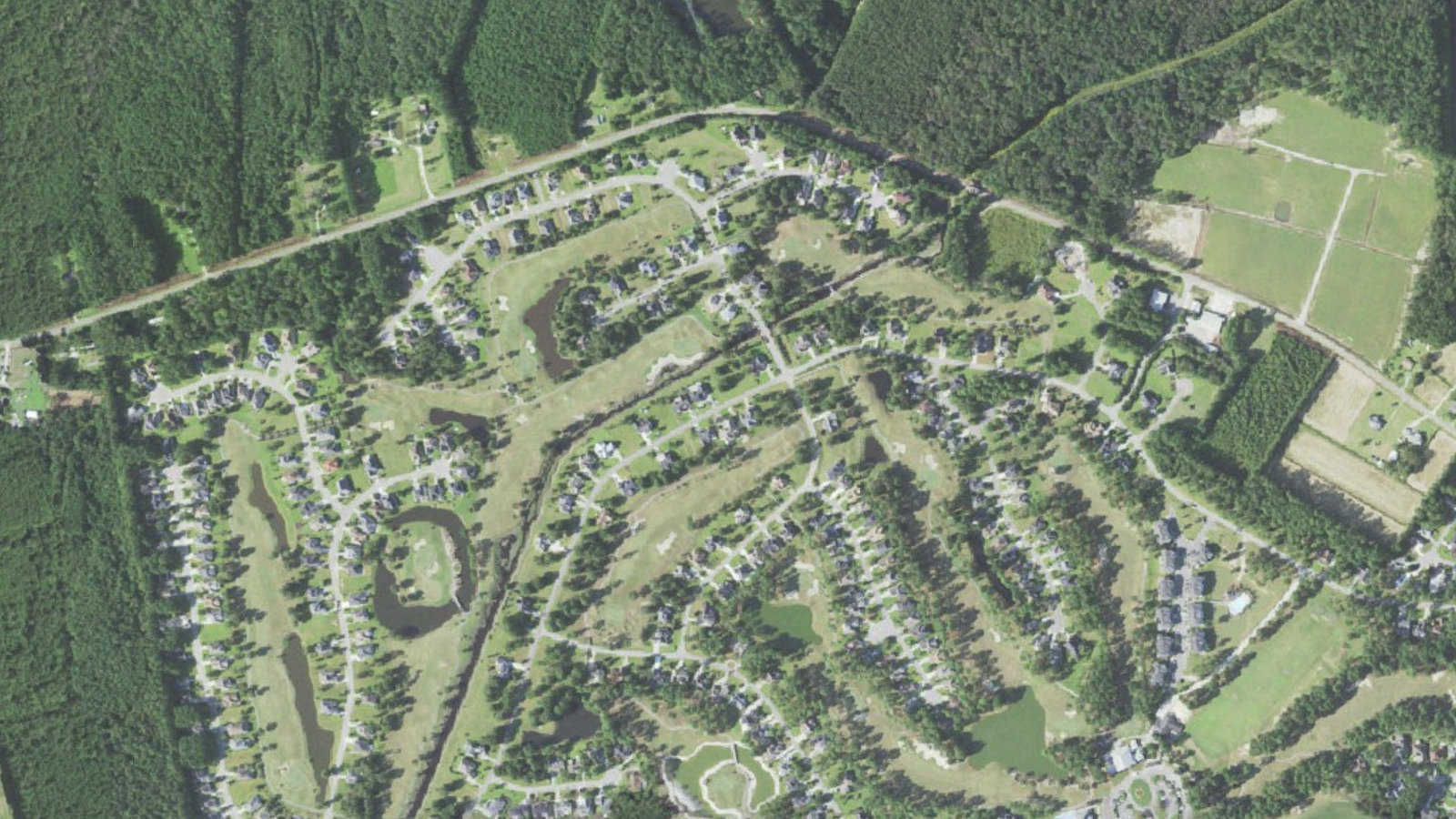 Aerial view of golf holes, ponds and single-family homes along North Middleton Drive NW in Brunswick Plantation, Calabash, North Carolina