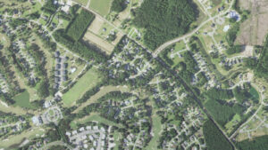 Aerial view of the US 17 corridor crossing Brunswick Plantation, with condominium buildings, homes and fairways on both sides, Calabash, North Carolina
