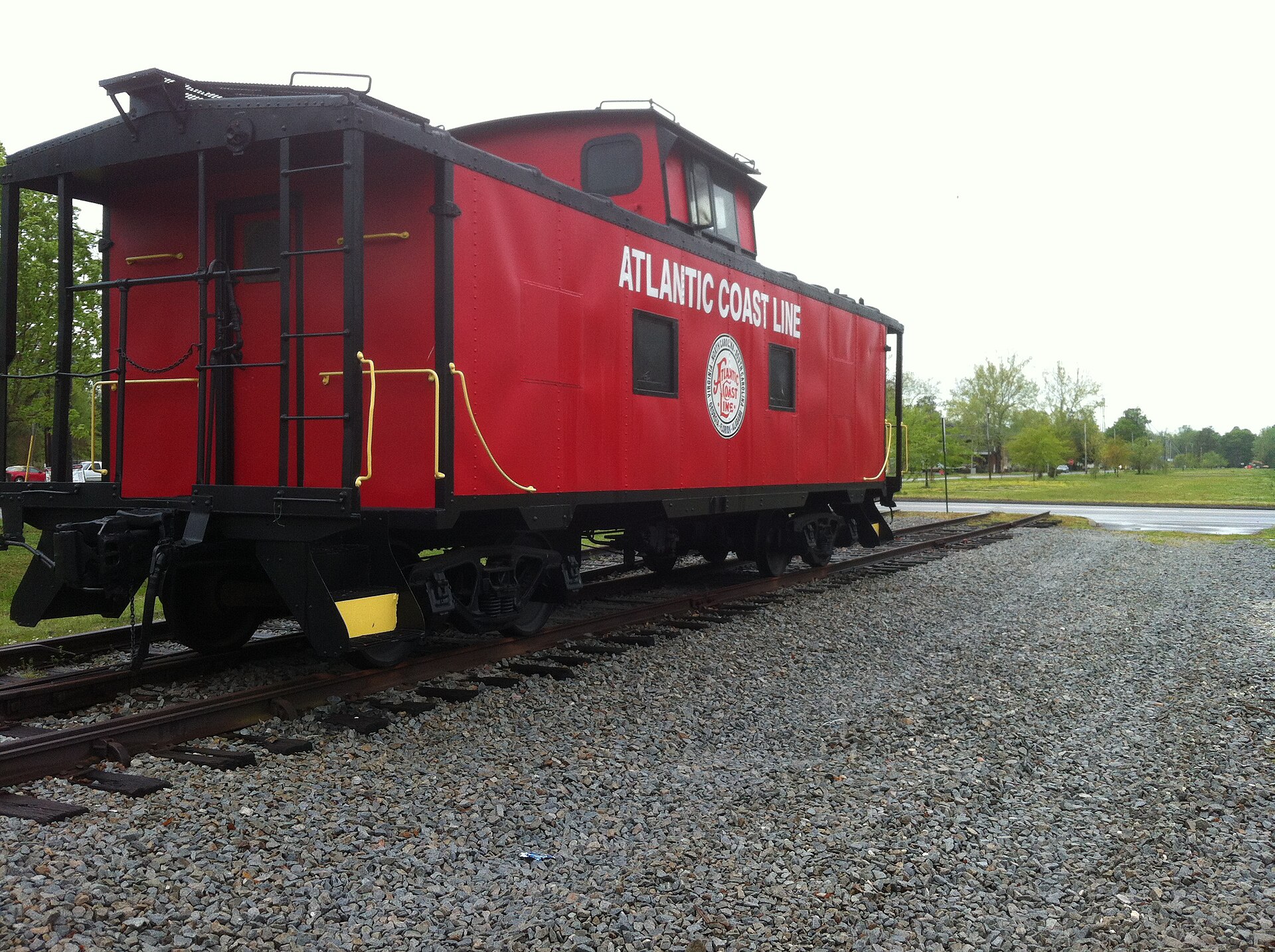 A red Atlantic Coast Line caboose on display track beside the Burgaw train depot in Burgaw, North Carolina