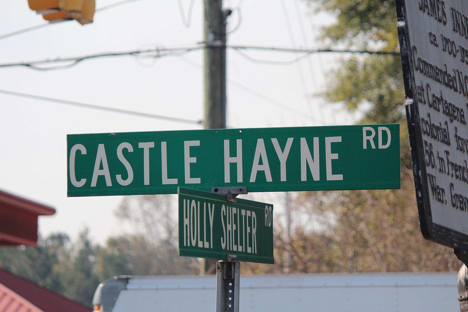 Street signs for Castle Hayne Road and Holly Shelter Road beside the James Innes historical marker