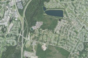 Aerial view of the northern edge of King's Grant in Wilmington, North Carolina, showing the thirty-five acre lake at Smith Creek Park, the Gordon Road corridor, and the Interstate 40 interchange at left