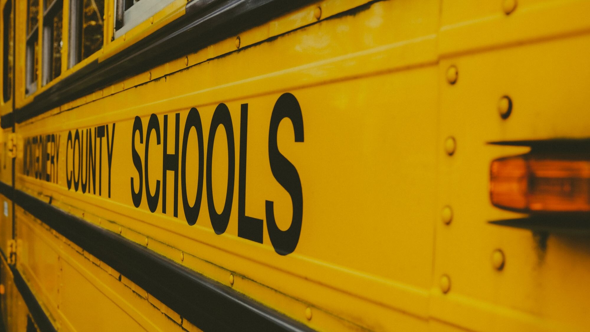 The side of a yellow county school bus, lettered COUNTY SCHOOLS, illustrating the New Hanover County Schools assignment question for Kings Grant in Wilmington, North Carolina.