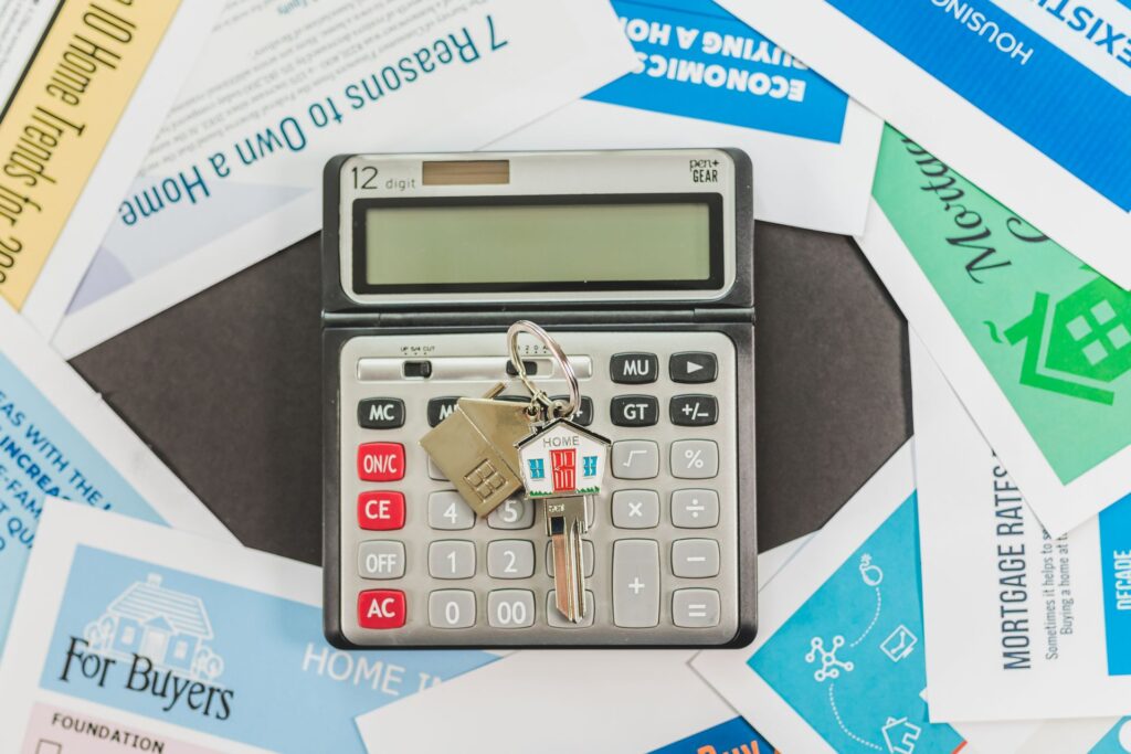 Calculator, house keys and mortgage paperwork spread on a table
