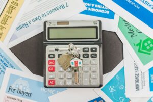 Calculator, house keys and mortgage paperwork spread on a table