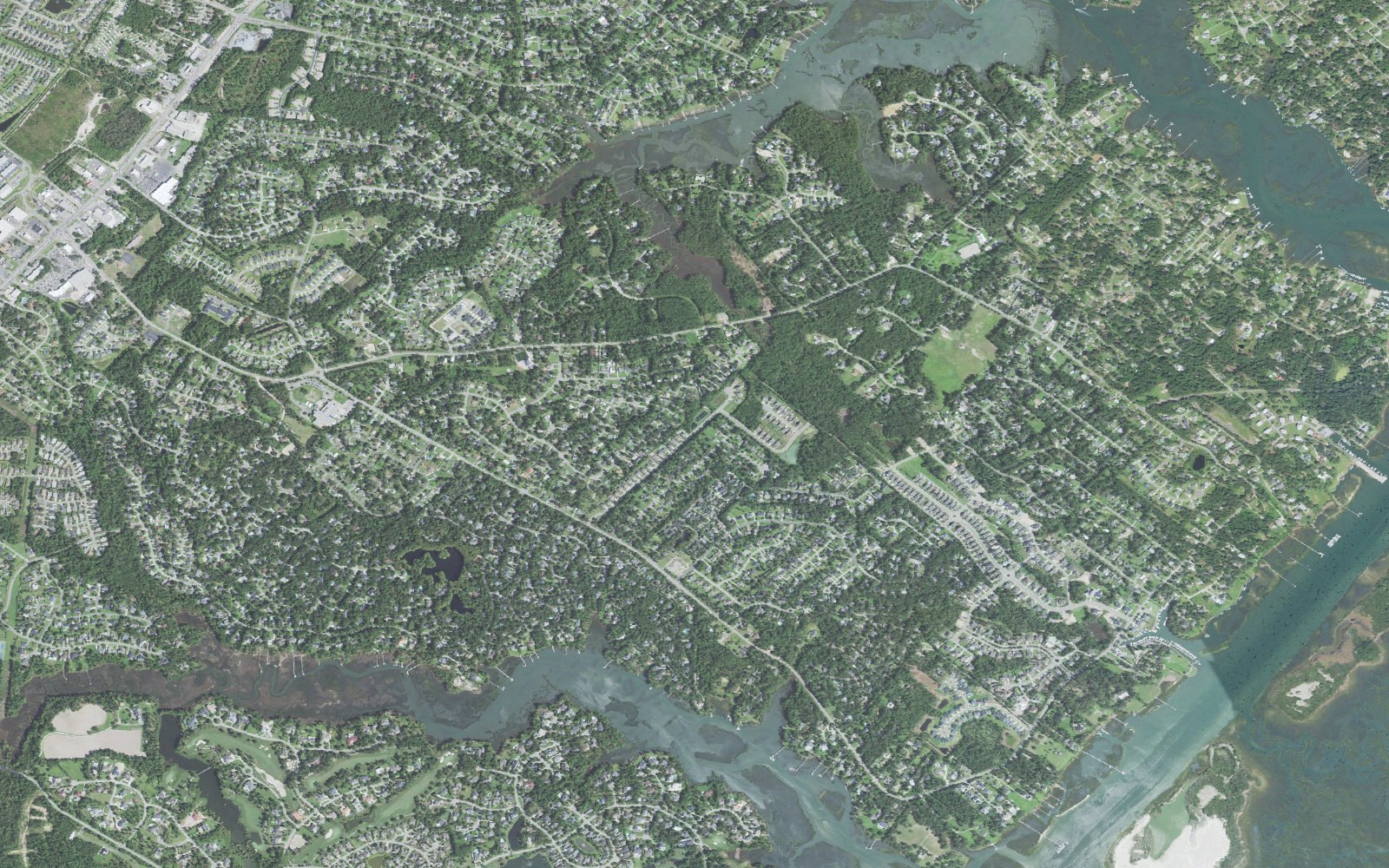 Aerial view of Ogden, North Carolina, with the Market Street corridor and its shopping centers at upper left, subdivisions filling the middle, tidal creeks winding east and the Intracoastal Waterway along the right edge