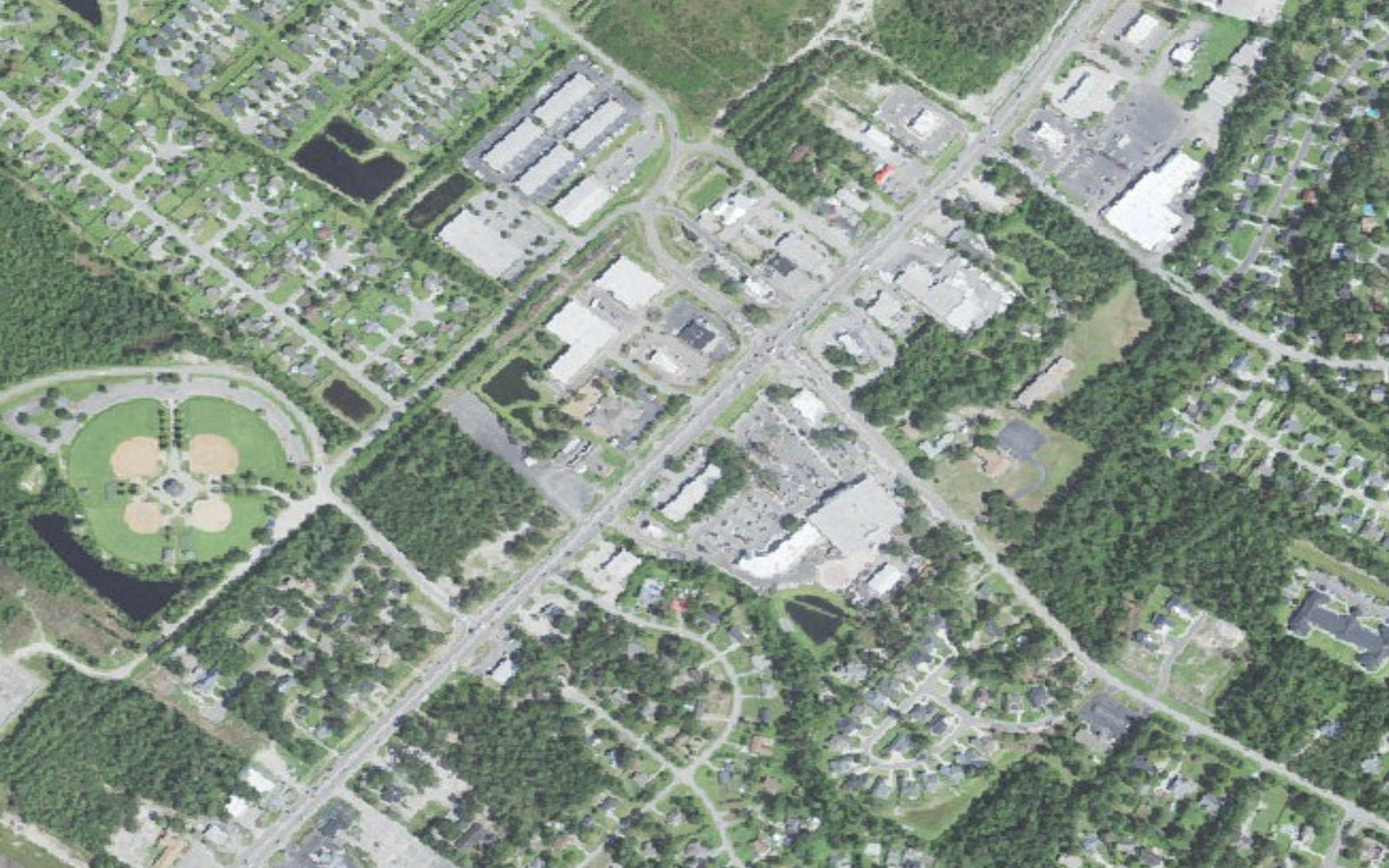 Aerial view of the Market Street commercial corridor through Ogden, North Carolina, with shopping centers, apartment buildings and single-family subdivisions on both sides