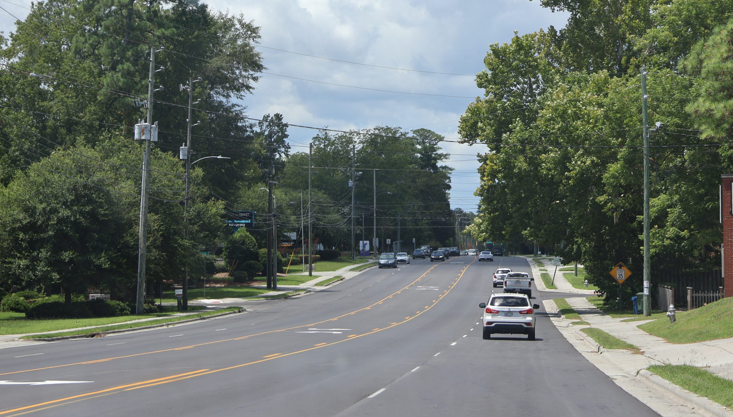 Traffic on Market Street in Wilmington, North Carolina, looking along the residential stretch of the corridor with homes and sidewalks on both sides