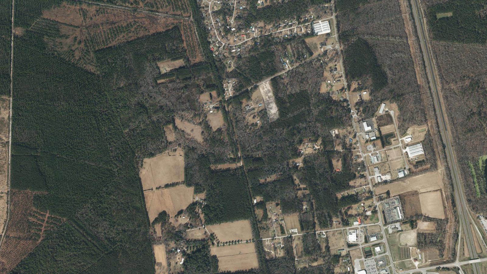 Aerial view of the US Highway 117 corridor through Rocky Point, North Carolina, with farm fields, woodland and scattered homes
