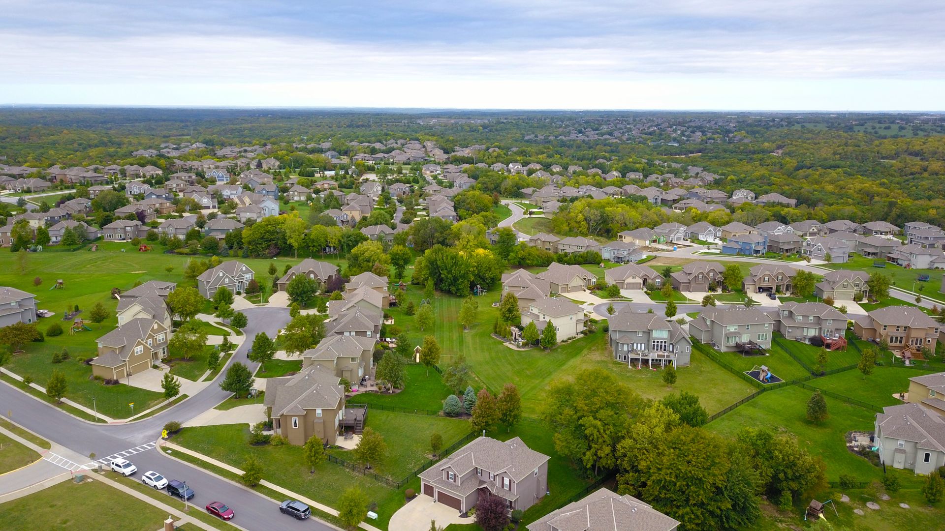 Aerial view of a suburban neighborhood of single-family homes and tree-lined streets