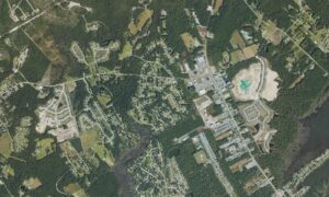 Aerial view of the mainland side of Surf City, North Carolina, west of the Intracoastal Waterway, showing newer subdivisions, shopping and commercial development along the N.C. 50 and N.C. 210 corridor and the wooded land still being cleared