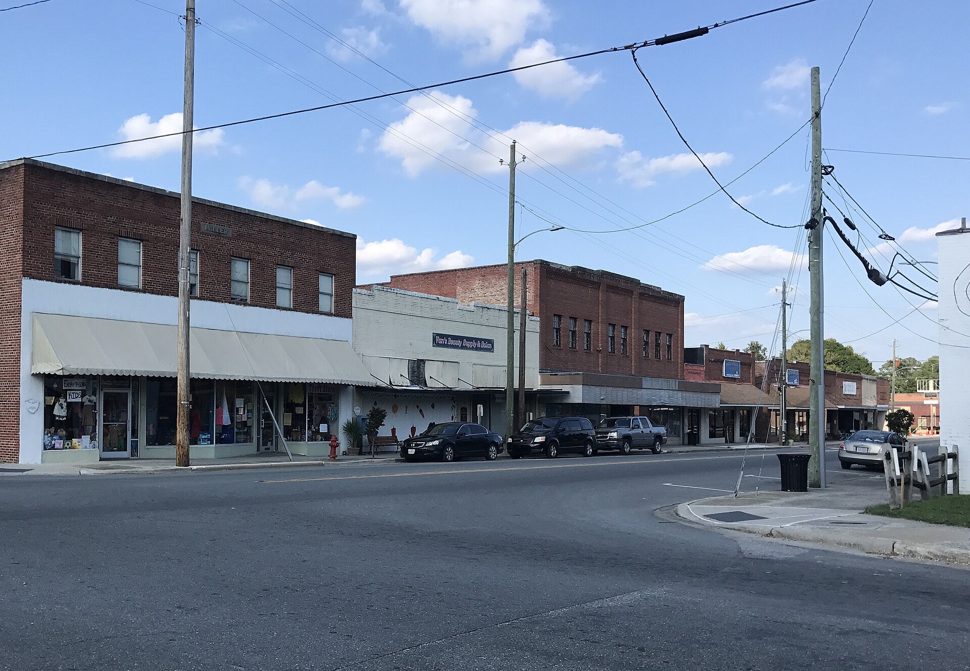 Brick storefronts and parked cars on the commercial block in Wallace, Duplin County, North Carolina