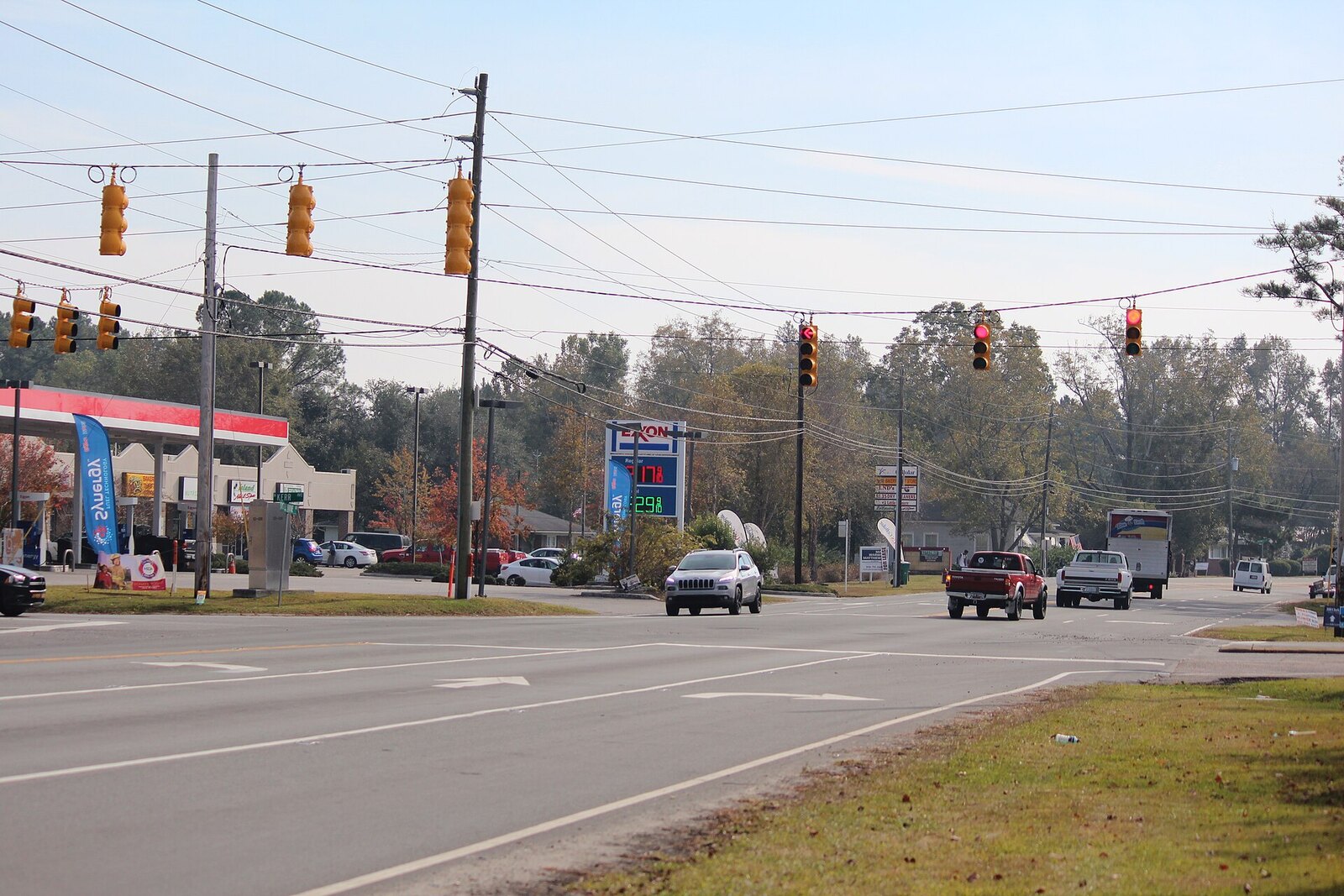 Castle Hayne Road at North Kerr Avenue in Wrightsboro, New Hanover County, North Carolina, with a gas station and strip retail on the corner and pine woods behind